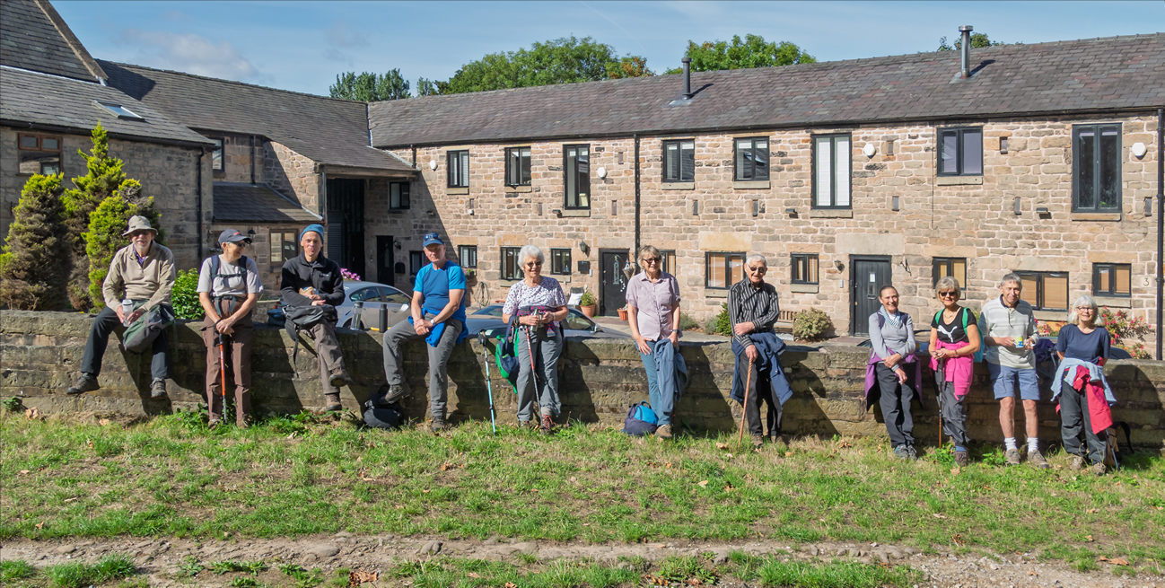 Walking group members beside a stone wall in Bidston